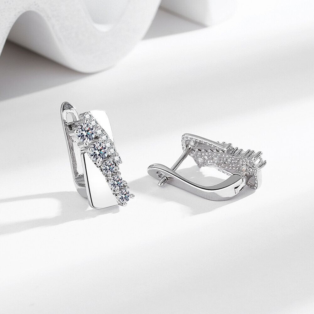 Silberne Ohrringe mit funkelnden Zirkonia-Steinen auf weißem Hintergrund, eleganter Schmuck