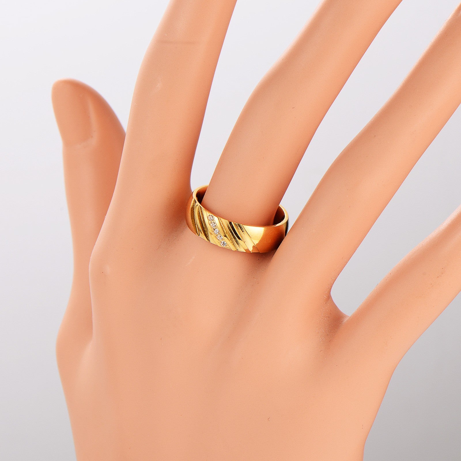 Goldener Ring mit Zirkonia und Muster auf Handmodell, eleganter Schmuck für Damen