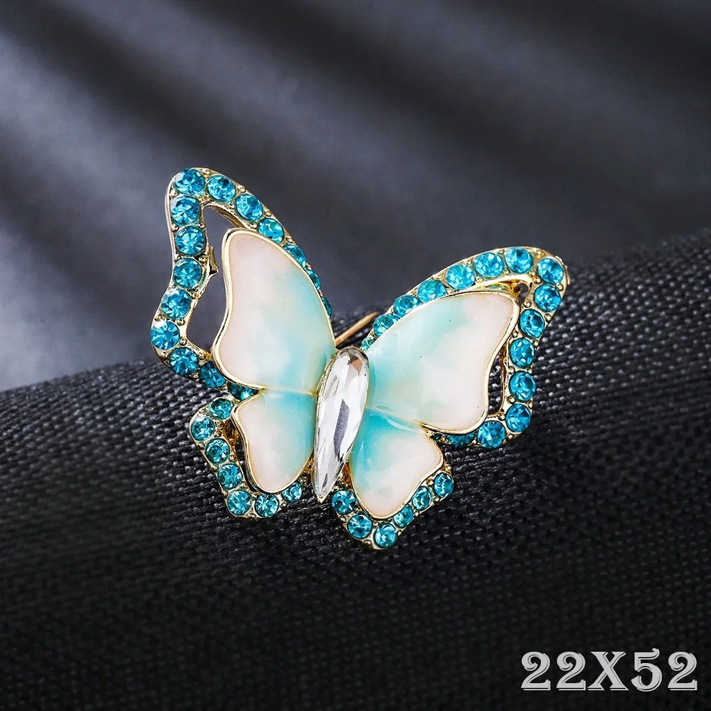 Schmetterling Brosche mit blauen Strasssteinen, eleganter Modeschmuck auf schwarzem Stoff