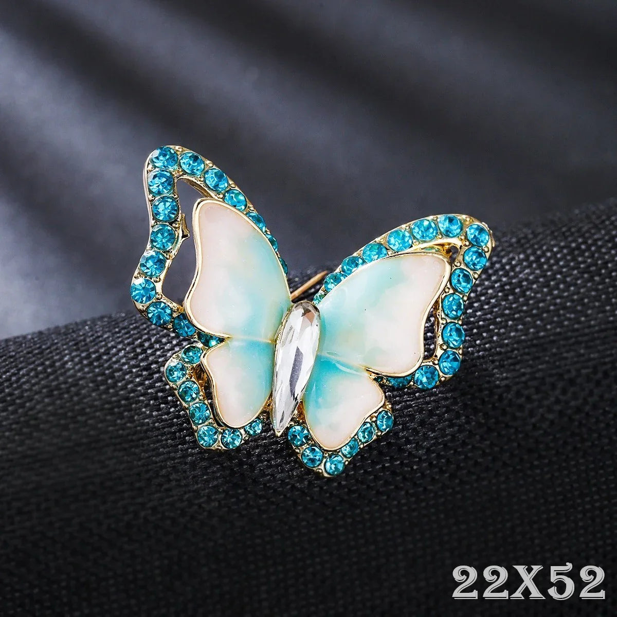 Schmetterling Brosche mit blauen Strasssteinen, eleganter Modeschmuck auf schwarzem Stoff