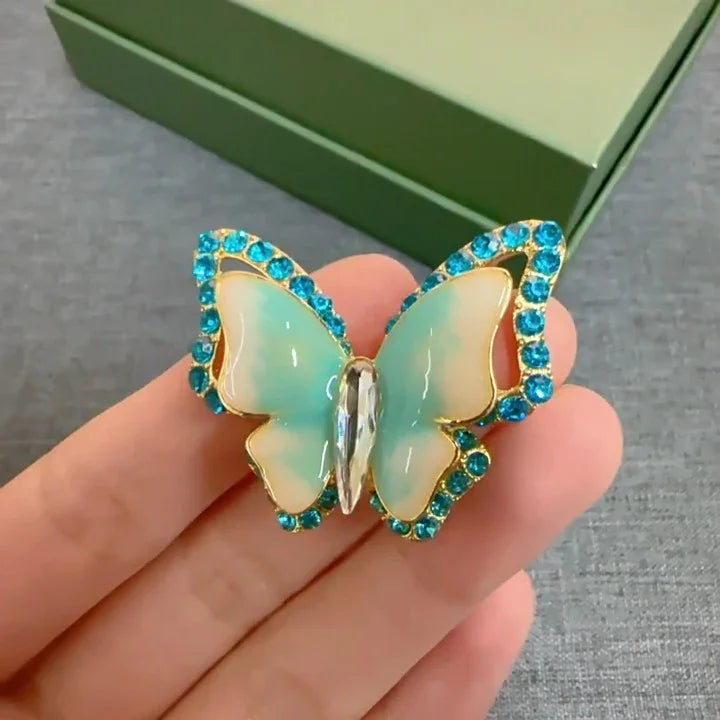 Schmetterling Brosche mit blauen Kristallen und Perlmutt-Flügeln auf Hand, Damenschmuck