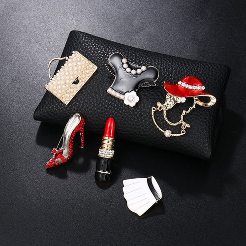 Mode Broschen Set für Damen mit Handtasche, Kleid, Hut, High Heel, Lippenstift und Fächer auf schwarzem Lederetui