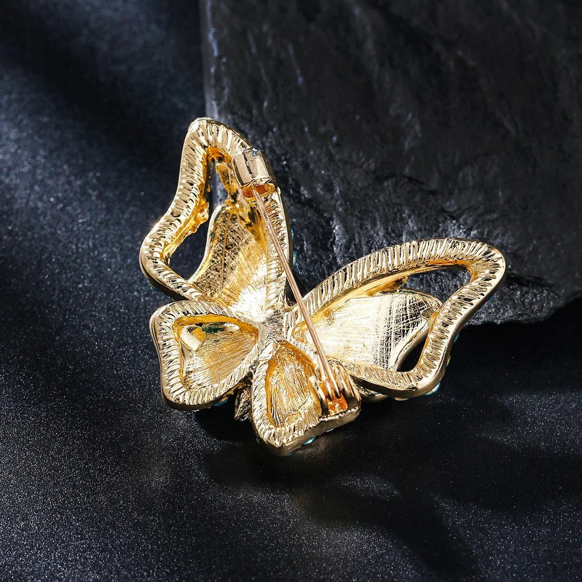 Goldene Schmetterling Brosche Schmuck, glänzend auf dunklem Hintergrund