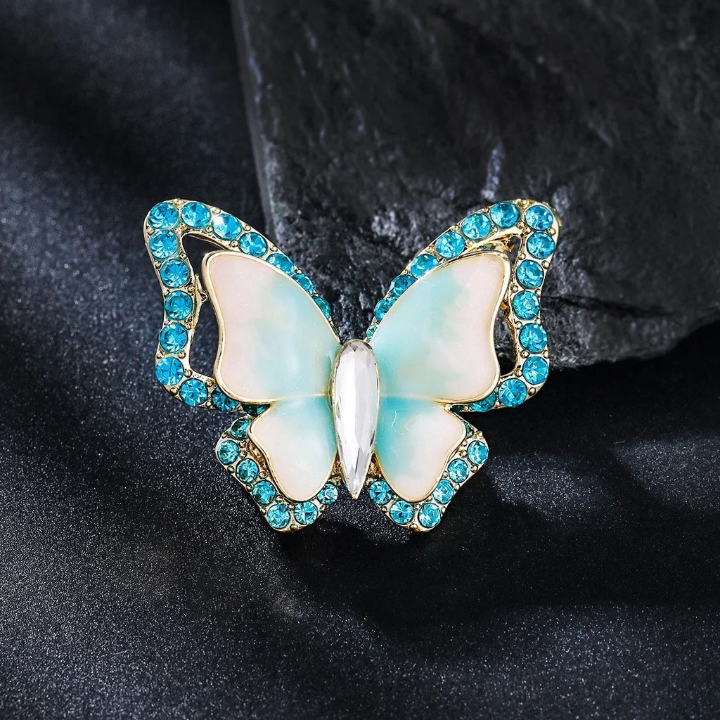 Schmetterling Brosche mit blauen Strasssteinen und Perlmuttflügeln, elegantes Schmuckstück